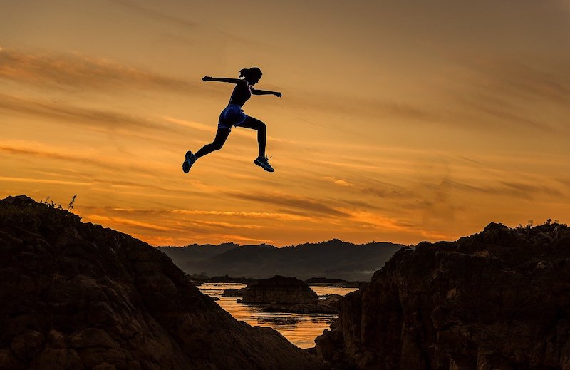 Leap of faith. Person leaping with the sunset in the background